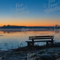 Tranquil Sunrise Over Serene Lake with Empty Bench