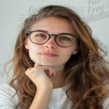 Thoughtful Young Woman with Glasses and Wavy Hair - Portrait for Lifestyle and Wellness Themes