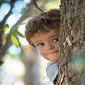 Playful Child Peeking from Behind a Tree in Nature